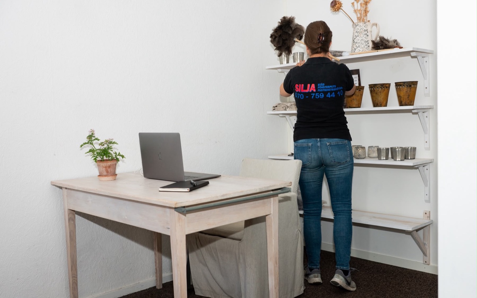 Medarbetare från Silja Städ dammar hyllor i en kontorsmiljö